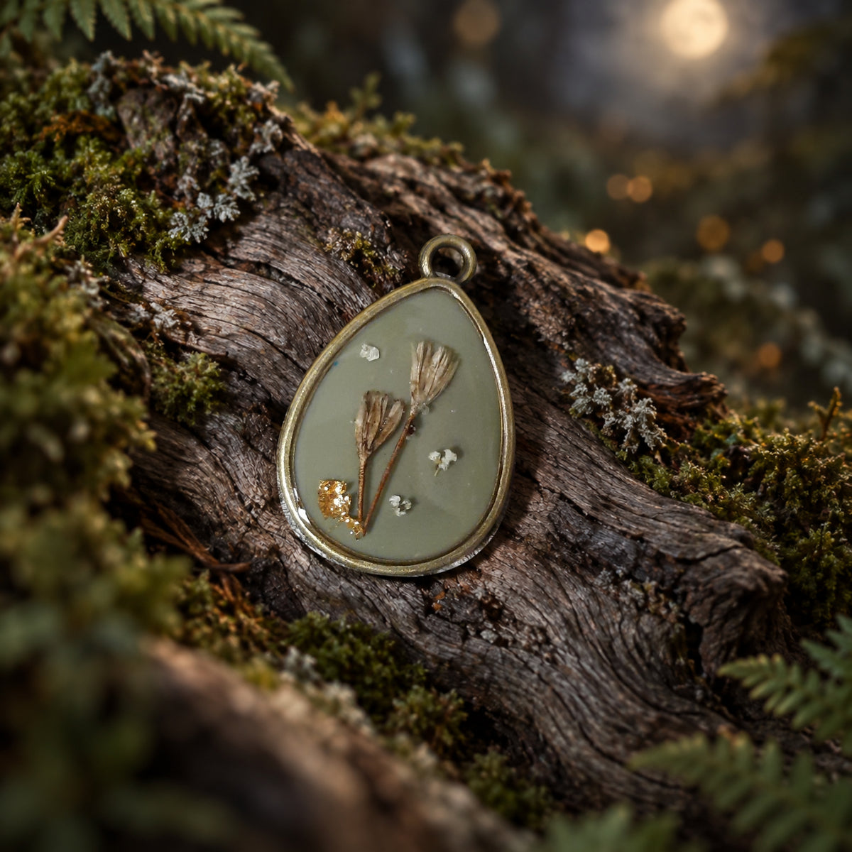 Graugrüner Resin-Blütenanhänger, 3 × 2 cm, auf Holz mit mystischem Waldhintergrund
